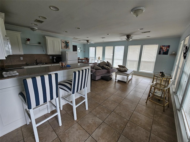 970 Olive Dr, Crystal Beach, TX 77650 - kitchen featuring freestanding refrigerator, ornamental molding, a sink, decorative backsplash, and a ceiling fan
