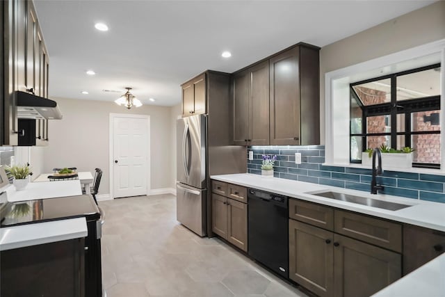 4266 T C Jester Blvd, Houston, TX 77018 - kitchen featuring black appliances, a sink, under cabinet range hood, decorative backsplash, and light countertops