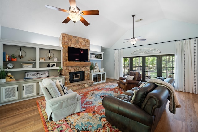 living room featuring ceiling fan, wood finished floors, a fireplace, and high vaulted ceiling