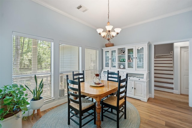 dining space featuring a chandelier, crown molding, stairway, light wood-type flooring, and baseboards