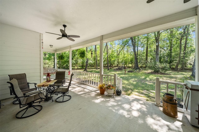 view of patio / terrace with ceiling fan and view of scattered trees