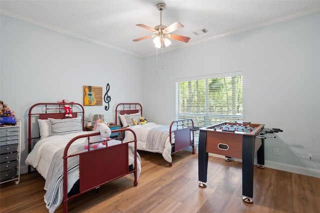 bedroom with ornamental molding, wood finished floors, baseboards, and a ceiling fan