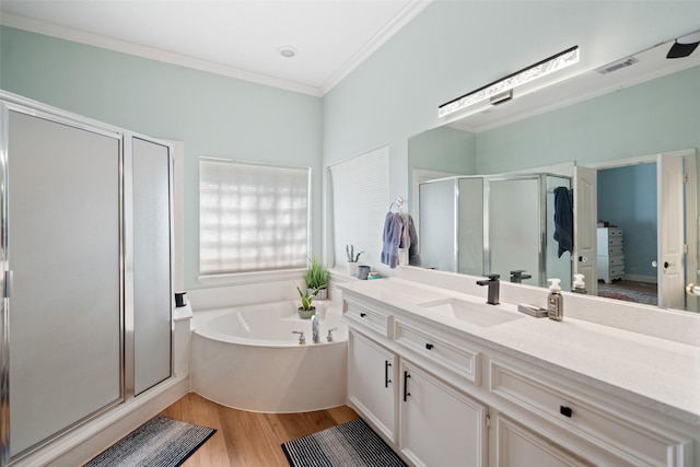 bathroom with a shower stall, a bath, wood finished floors, ornamental molding, and vanity