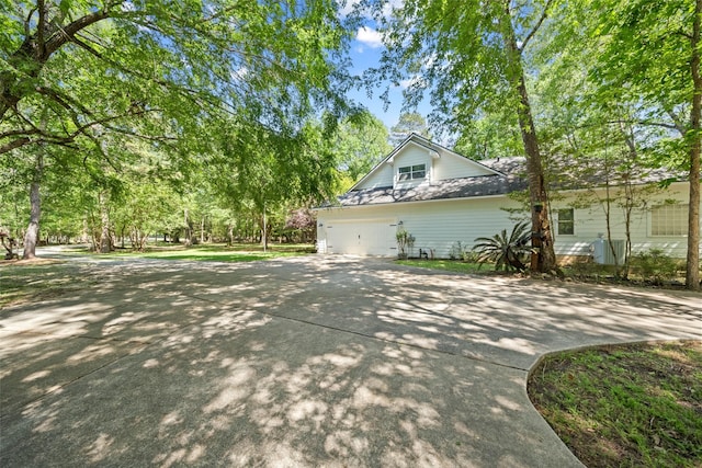 view of side of property with concrete driveway and a garage
