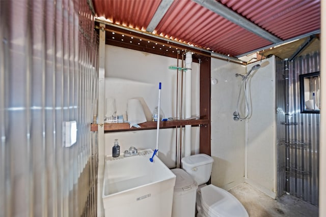 bathroom featuring toilet, a sink, concrete flooring, and a shower