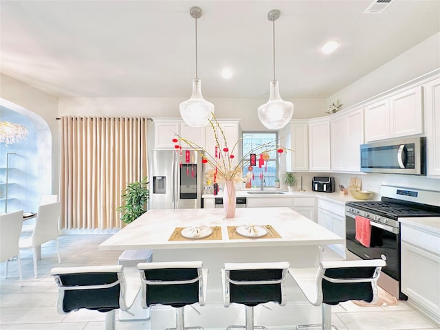 7014 Anacua Berry Cir, Katy, TX 77493 - kitchen featuring appliances with stainless steel finishes, a center island, light countertops, white cabinetry, and recessed lighting