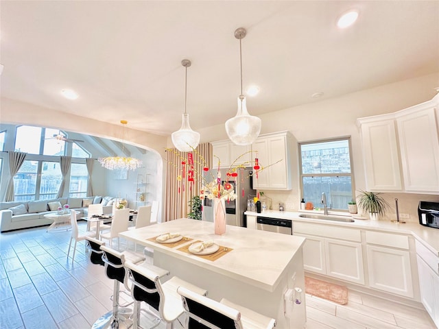7014 Anacua Berry Cir, Katy, TX 77493 - kitchen featuring a sink, open floor plan, light countertops, white cabinetry, and a kitchen bar