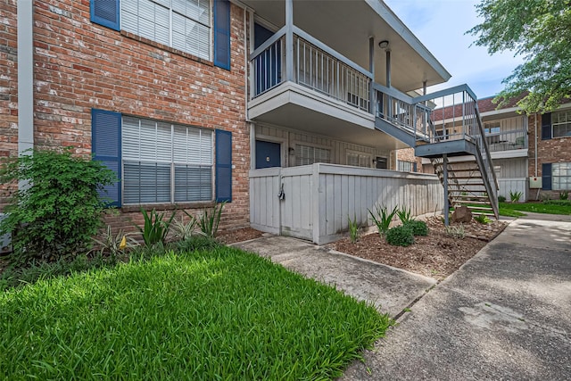 2250 Bering Dr Unit 101, Houston, TX 77057 - view of exterior entry featuring brick siding, fence, a balcony, and a gate