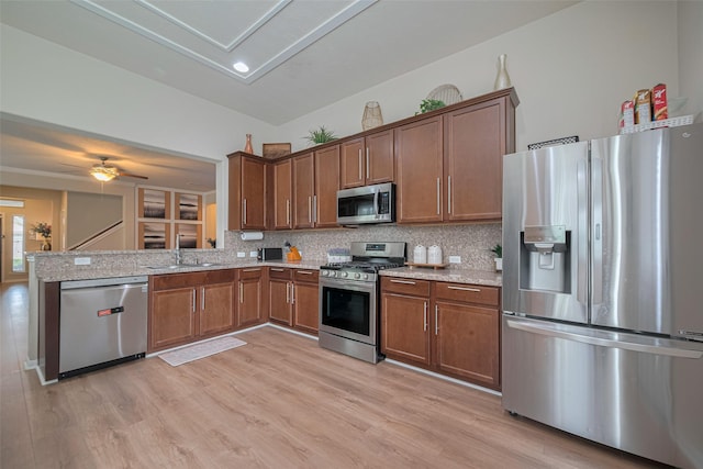 8113 E Pine Creek Bnd, Cypress, TX 77433 - kitchen featuring appliances with stainless steel finishes, backsplash, light stone countertops, and light wood finished floors
