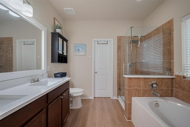 8113 E Pine Creek Bnd, Cypress, TX 77433 - full bathroom featuring a stall shower, toilet, a bath, wood finished floors, and double vanity