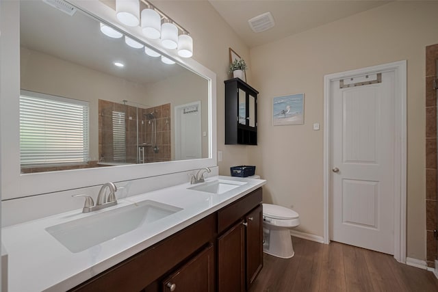 8113 E Pine Creek Bnd, Cypress, TX 77433 - full bath featuring a tile shower, wood finished floors, toilet, double vanity, and baseboards