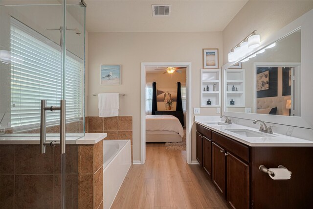 8113 E Pine Creek Bnd, Cypress, TX 77433 - full bathroom with ensuite bathroom, wood finished floors, a bath, double vanity, and a ceiling fan
