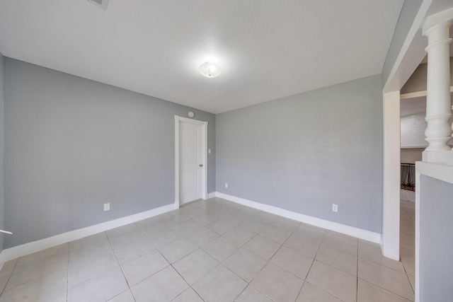 722 Dell Dale St, Channelview, TX 77530 - spare room featuring baseboards, light tile patterned flooring, a textured ceiling, and ornate columns