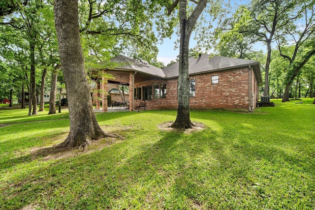 123 June Blvd, Streetman, TX 75859 - rear view of house with brick siding, a lawn, and a shingled roof