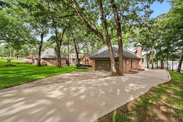 123 June Blvd, Streetman, TX 75859 - view of front facade with brick siding, driveway, an attached garage, a chimney, and a front lawn