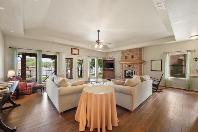 123 June Blvd, Streetman, TX 75859 - living room featuring a raised ceiling, a fireplace, and dark wood-style floors