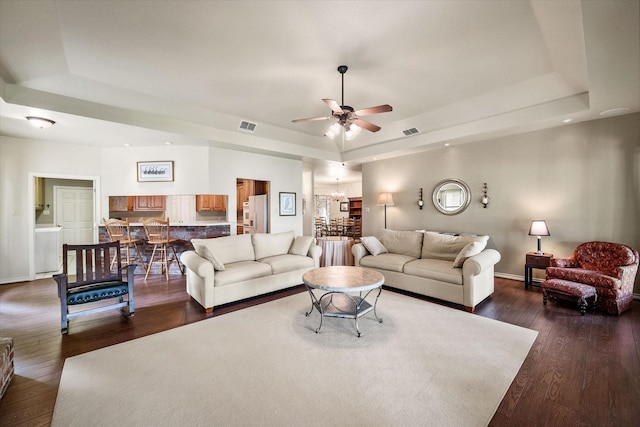 123 June Blvd, Streetman, TX 75859 - living area featuring a raised ceiling, a ceiling fan, dark wood finished floors, and a chandelier