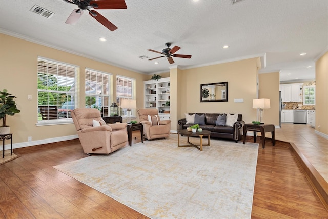 18106 E Cypress Hill Cir, Cypress, TX 77433 - living room with ceiling fan, crown molding, light wood-style flooring, plenty of natural light, and a textured ceiling