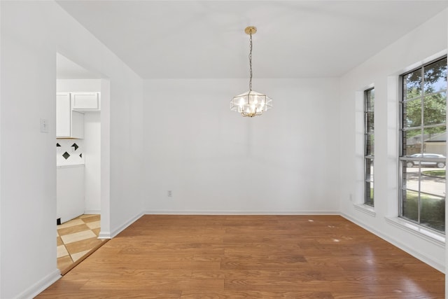 6414 Windmist Cir, Houston, TX 77084 - unfurnished dining area with a chandelier, light wood finished floors, and baseboards