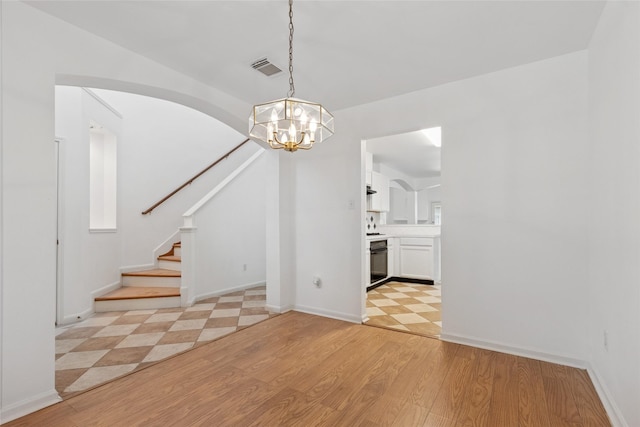 6414 Windmist Cir, Houston, TX 77084 - unfurnished dining area featuring a chandelier, stairway, light wood-style flooring, and baseboards