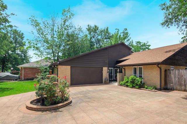 10022 Jan Glen Ln, Houston, TX 77070 - mid-century home with curved driveway, brick siding, an attached garage, and fence