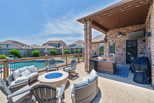 view of patio with an outdoor living space with a fire pit, a ceiling fan, a fenced backyard, and a residential view
