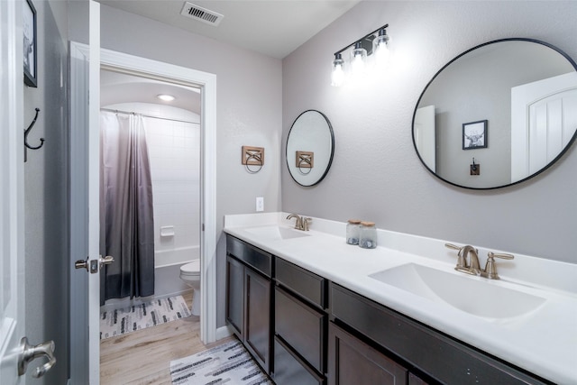 full bath with wood finished floors, toilet, double vanity, and shower / bath combination with curtain