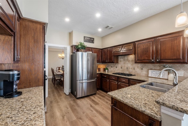 17326 Meadow Heights Dr, Houston, TX 77095 - kitchen featuring freestanding refrigerator, a sink, decorative backsplash, light stone countertops, and a textured ceiling