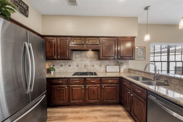 17326 Meadow Heights Dr, Houston, TX 77095 - kitchen with appliances with stainless steel finishes, a sink, backsplash, light wood-style flooring, and light stone counters