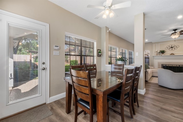 17326 Meadow Heights Dr, Houston, TX 77095 - dining space with wood finished floors, ceiling fan, baseboards, and a fireplace