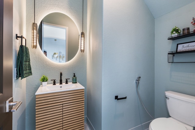 half bathroom with toilet, vanity, a textured wall, and vaulted ceiling