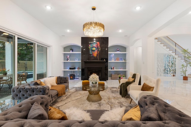 living room with built in features, a chandelier, stairway, a large fireplace, and recessed lighting