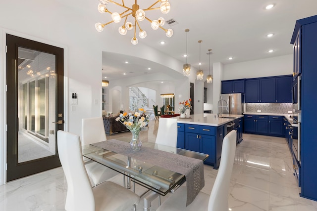 dining room with arched walkways, a chandelier, light marble finish floors, and recessed lighting