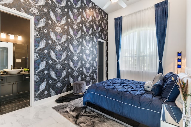 bedroom featuring wallpapered walls, a sink, and ensuite bath