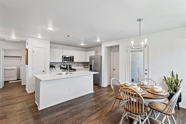 2117 Heritage Meadow Ln, Bryan, TX 77803 - kitchen featuring stainless steel appliances, washer / dryer, a sink, dark wood finished floors, and light countertops