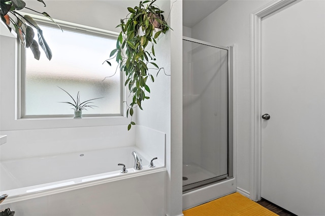 2117 Heritage Meadow Ln, Bryan, TX 77803 - bathroom with a stall shower, a bath, and wood finished floors