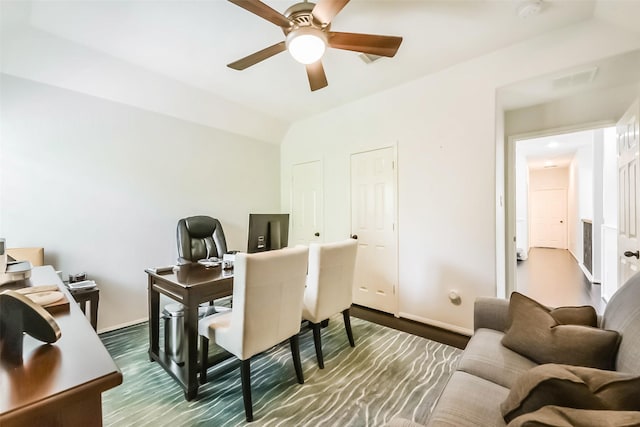 office space featuring a ceiling fan, dark wood-style floors, baseboards, and vaulted ceiling