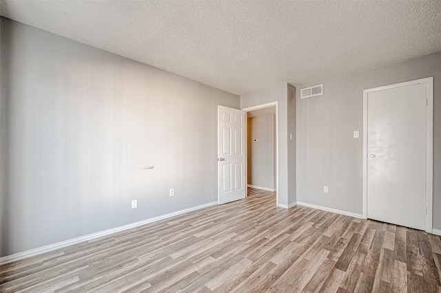 2818 S Bartell Dr Unit 39, Houston, TX 77054 - spare room featuring light wood-style floors, baseboards, and a textured ceiling