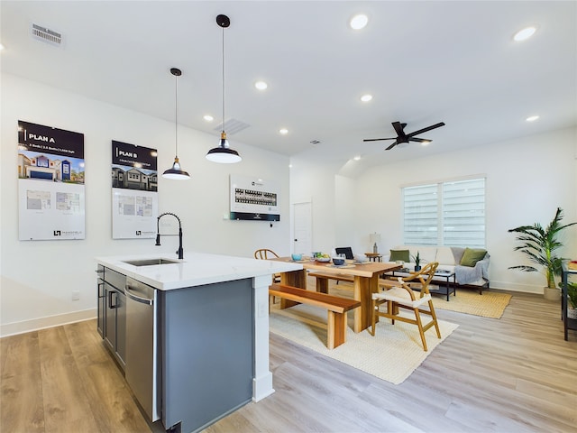 5808 Highland Sky Ln, Houston, TX 77091 - kitchen with a sink, stainless steel dishwasher, light wood-type flooring, a center island with sink, and pendant lighting