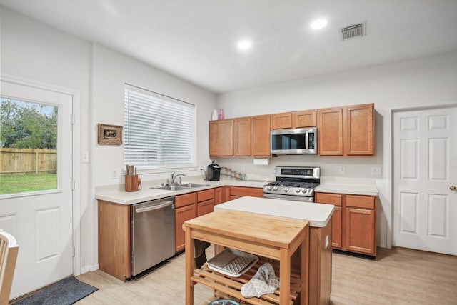723 Slate Valley Ln, Spring, TX 77373 - kitchen with appliances with stainless steel finishes, a sink, light countertops, light wood-style floors, and recessed lighting