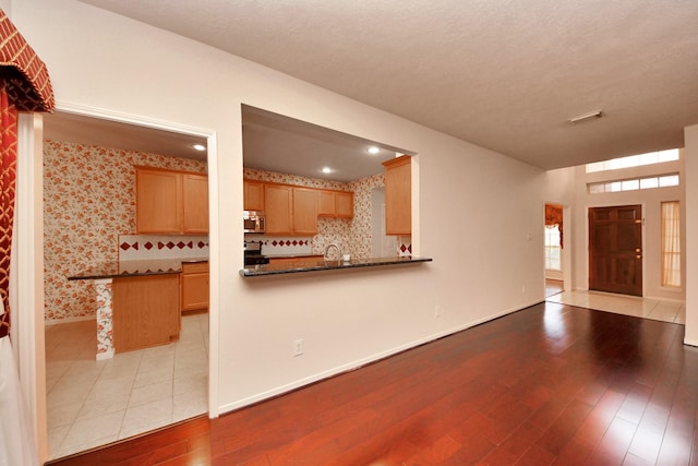 14731 Ravenscroft Way, Houston, TX 77083 - kitchen with stainless steel microwave, wood finished floors, dark countertops, and baseboards