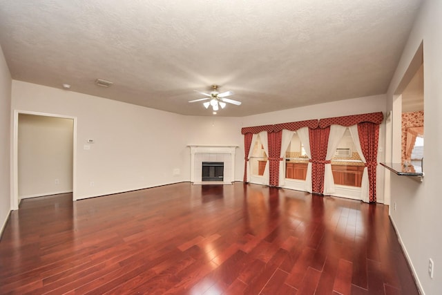 14731 Ravenscroft Way, Houston, TX 77083 - unfurnished living room featuring ceiling fan, wood finished floors, a tiled fireplace, baseboards, and a textured ceiling