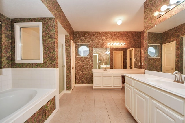 14731 Ravenscroft Way, Houston, TX 77083 - full bathroom with wallpapered walls, tile patterned floors, a bath, two vanities, and baseboards