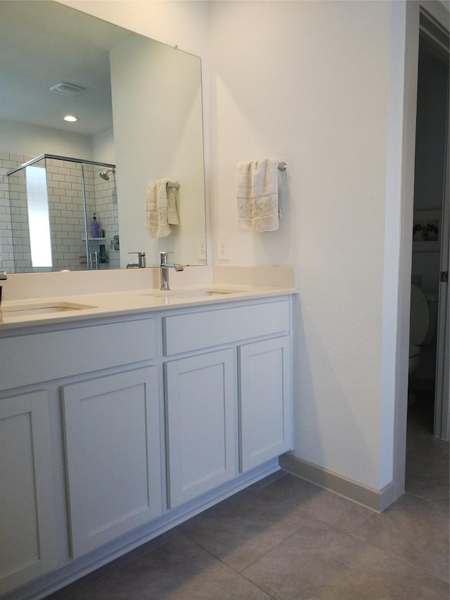 19027 Drayton Village Trce, Richmond, TX 77407 - full bathroom with a stall shower, double vanity, tile patterned floors, toilet, and baseboards