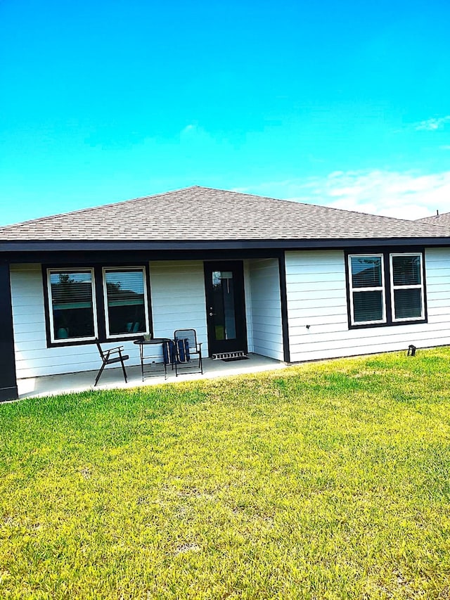 19027 Drayton Village Trce, Richmond, TX 77407 - back of house with a yard, a shingled roof, and covered porch