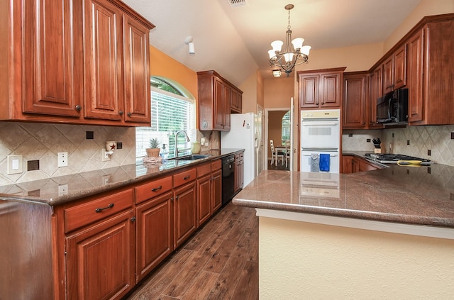 kitchen featuring a sink, black appliances, dark wood finished floors, a chandelier, and backsplash