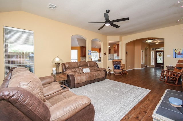 living room featuring ceiling fan, arched walkways, dark wood finished floors, and lofted ceiling