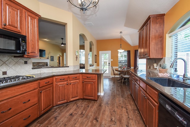 kitchen featuring black appliances, a sink, dark wood finished floors, arched walkways, and tasteful backsplash