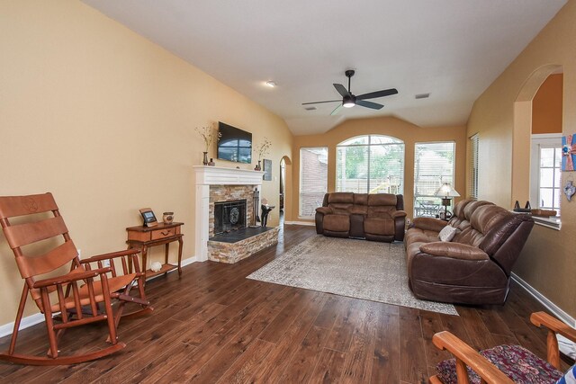 living area with a ceiling fan, arched walkways, dark wood-style flooring, a fireplace, and baseboards