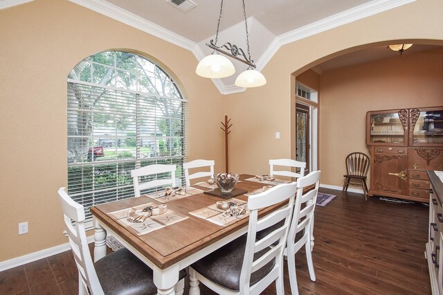 dining area featuring arched walkways, ornamental molding, dark wood finished floors, and baseboards